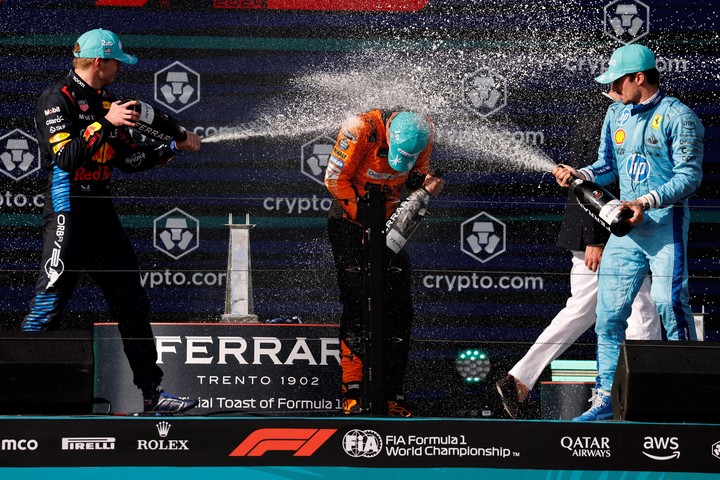 Max Verstappen y Charles Leclerc bañan en champán a Lando Norris en el podio de Miami.
Foto Reuters