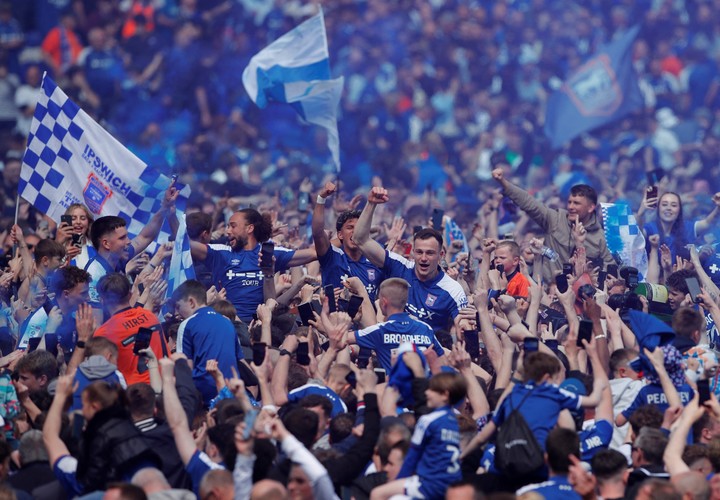 Los jugadores de Ipswich Town festejan el ascenso junto a los hinchas sobre el césped del Portman Road Stadium. Foto: Andrew Couldridge / Reuters.