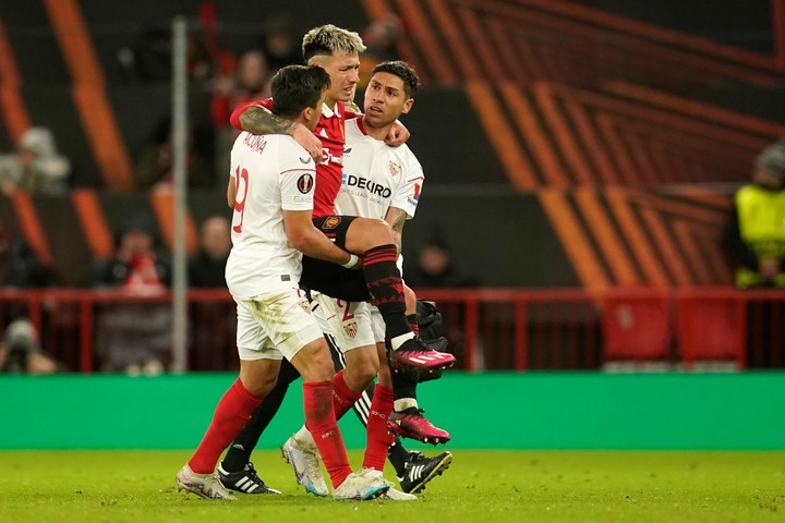 Montiel y Acuña ayudan a Lisandro Martínez a salir de la cancha. Foto: AP / Dave Thompson