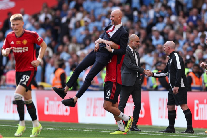 Lisandro Martínez, el '6', festeja con Erik Ten Hag mientras Guardiola saluda a uno de los árbitros. Foto: AP Photo/Ian Walton