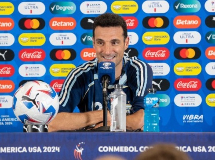 Scaloni, en conferencia de prensa con su medalla de campeón y cumpliendo la cábala de festejar con una casca retro. Foto: @Argentina