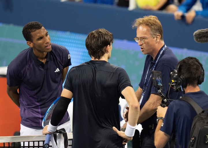 Felix Auger-Aliassime mira sin entender lo que pasó, con Jack Draper y las autoridades. Foto: Susan Mullane - USA TODAY Sports.