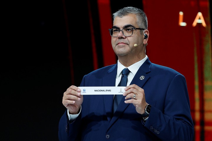 El director de competiciones de clubes de la Conmebol, Frederico Nantes, sotiene el nombre del equipo paraguayo Nacional. Foto: EFE / Juan Pablo Pino,