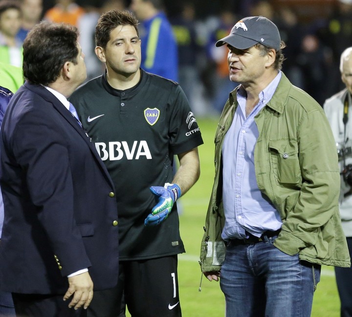 Roger Bello dialoga con Alejandro Burzaco en el campo de juego de la Bombonera con Orión como testigo. (AP)